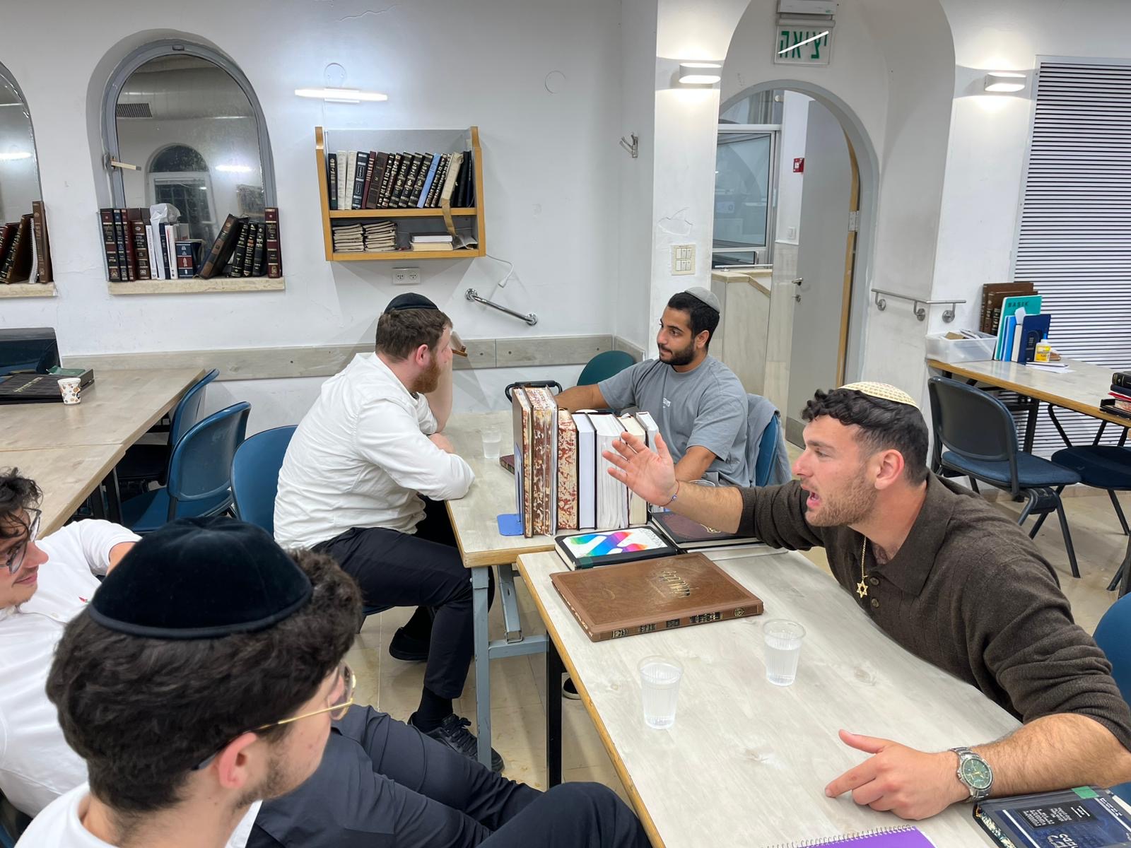 Akiva participants learning together around tables