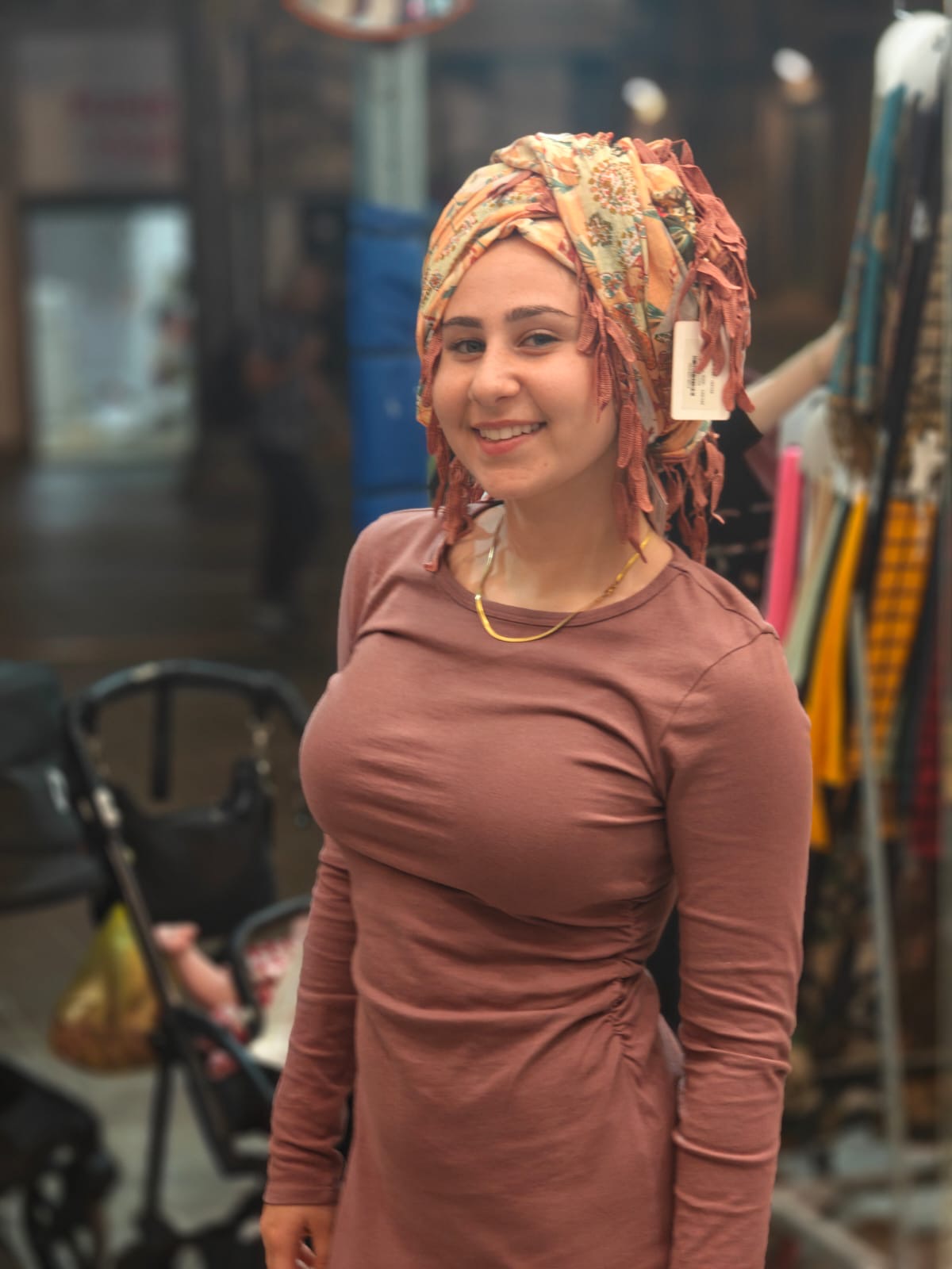 Akiva participant trying on a colorful scarf at a market